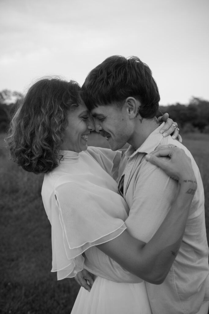 Up close photo of bride and groom smiling at each other in black and white on their wedding day