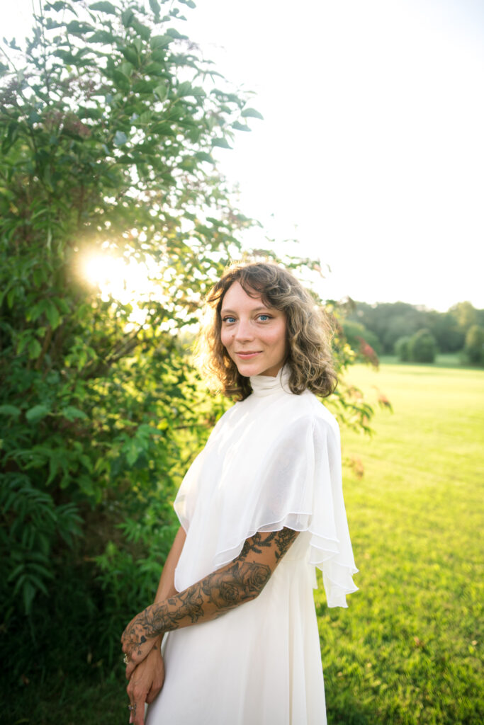 Bridal portrait of bride on wedding day with sun glowing behind 