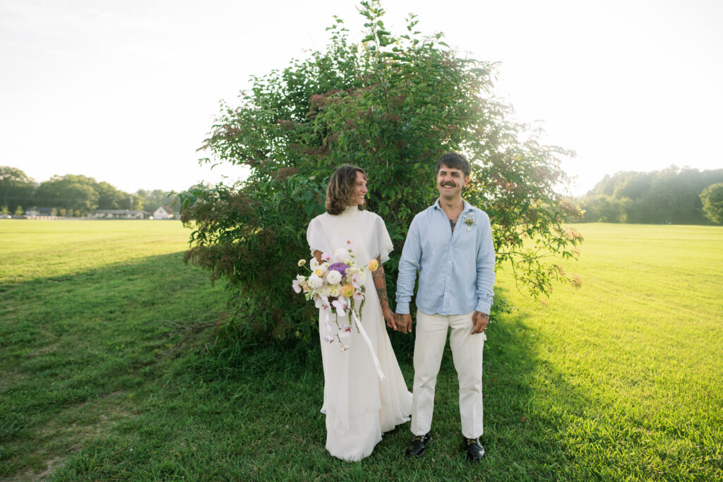 Photo of bride and groom smiling while holding hands at their post-wedding session