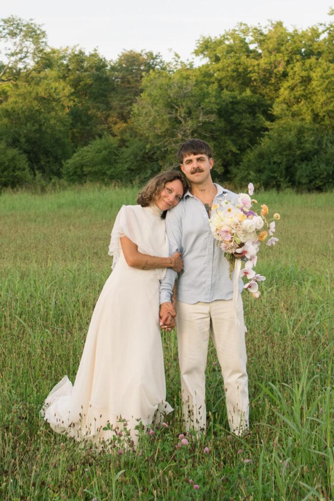 Bride and groom smiling at the camera while posing for a traditional wedding portraits 