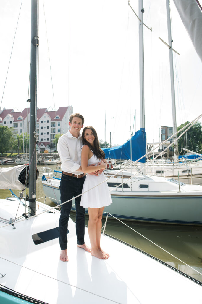 Couple posing for on their friends sailboat for their engagement photos in Louisville, Kentucky