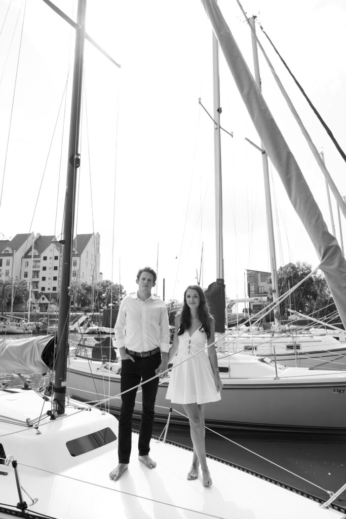 Couple posing for on their friends sailboat for their engagement photos in Louisville, Kentucky