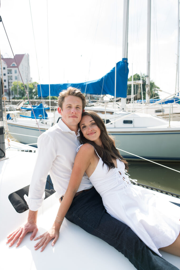 Couple posing for on their friends sailboat for their engagement photos in Louisville, Kentucky