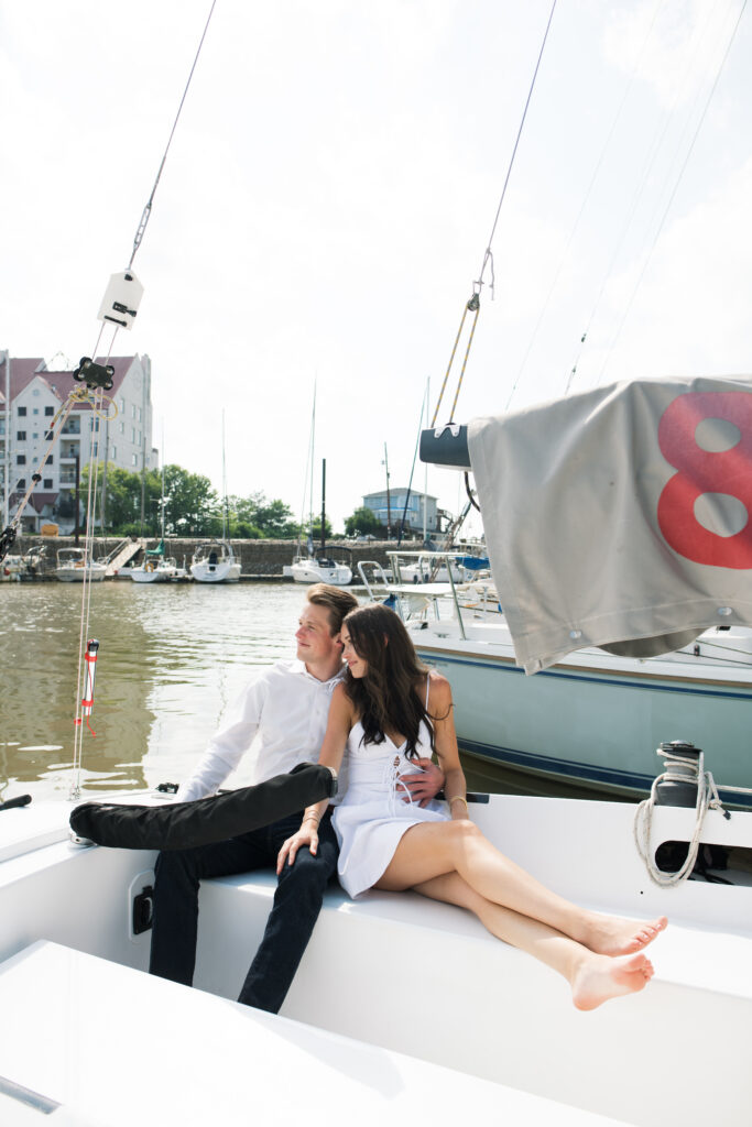 Couple posing for on their friends sailboat for their engagement photos in Louisville, Kentucky