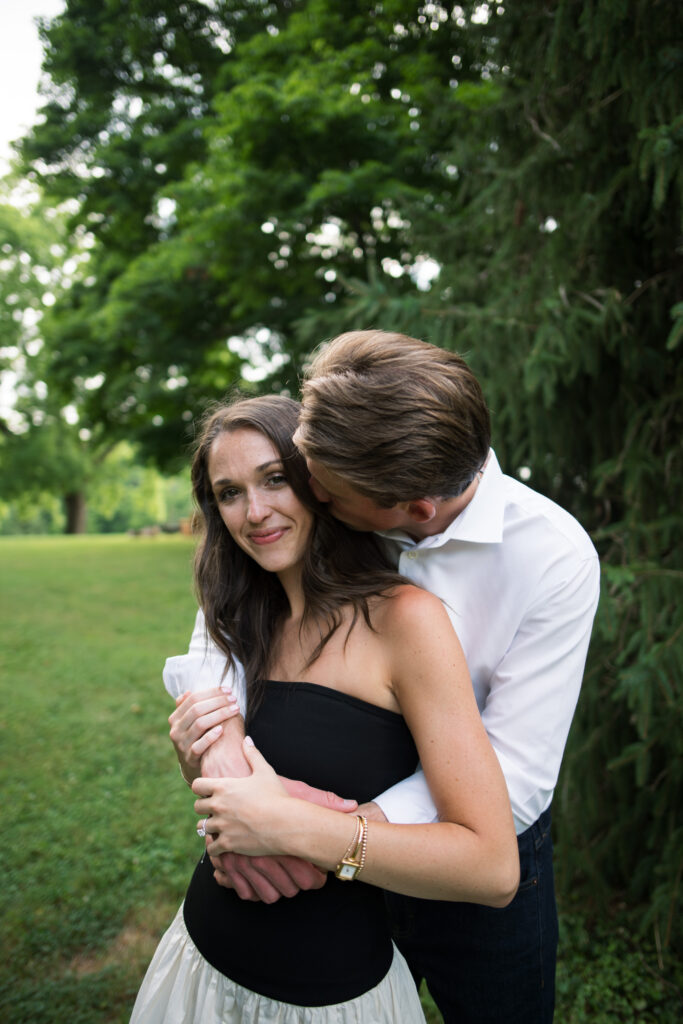 Couple posing for their engagement photos in their family backyard in Louisville, Kentucky