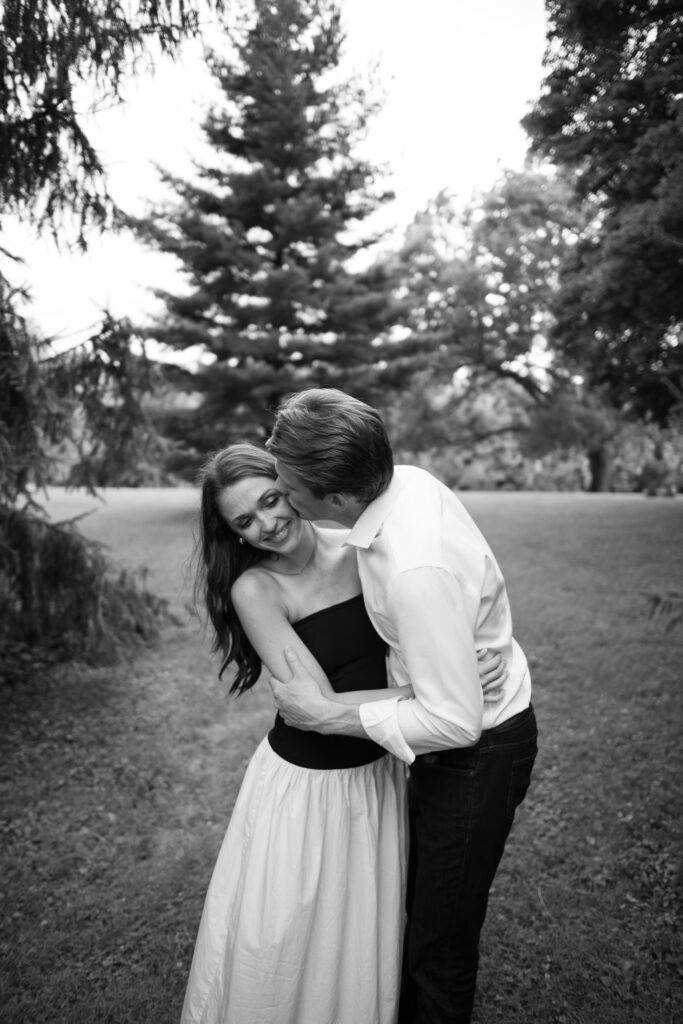 Couple posing for their engagement photos in their family backyard in Louisville, Kentucky