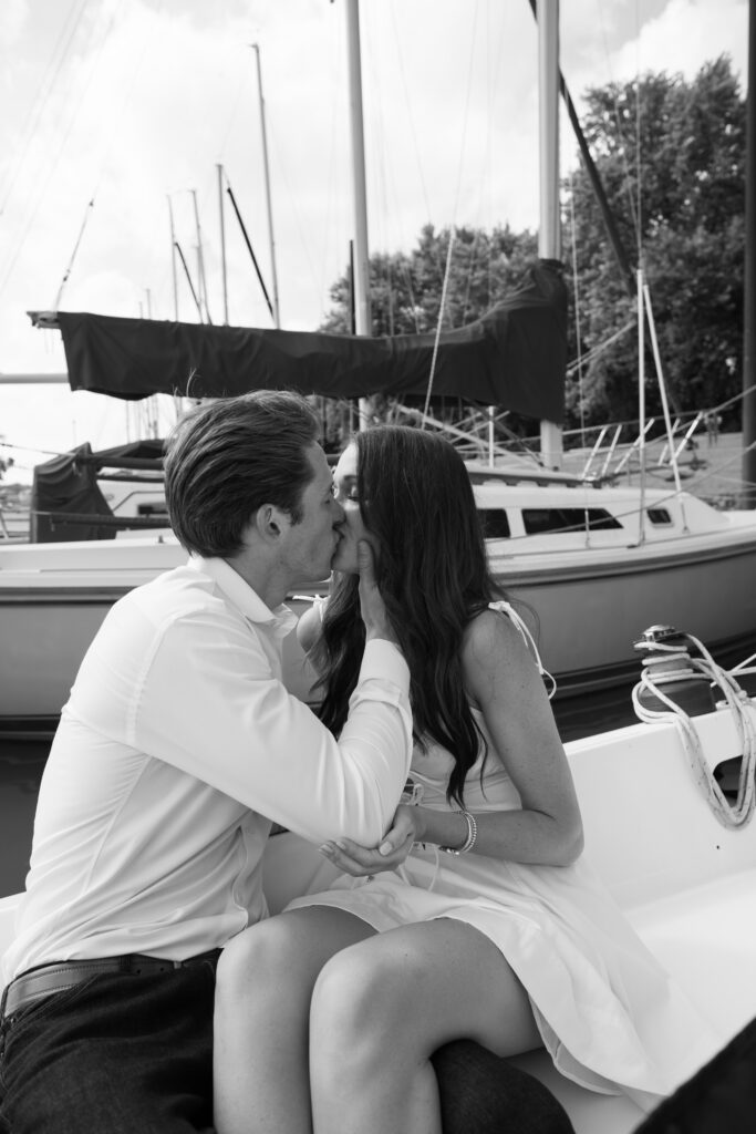 Couple posing for on their friends sailboat for their engagement photos in Louisville, Kentucky