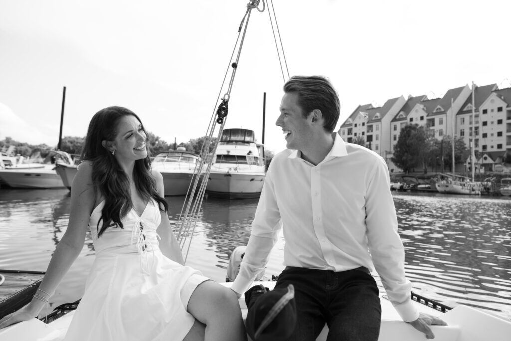 Couple posing for on their friends sailboat for their engagement photos in Louisville, Kentucky