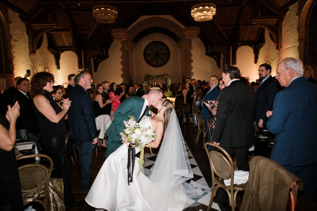 Bride and groom kissing at the end of the aisle at The Palomar