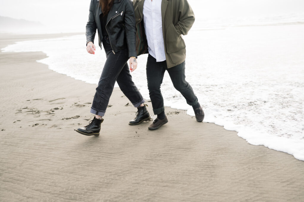 A couple walking toward the camera during their PNW Engagement session on the coast in Seaview, Washington