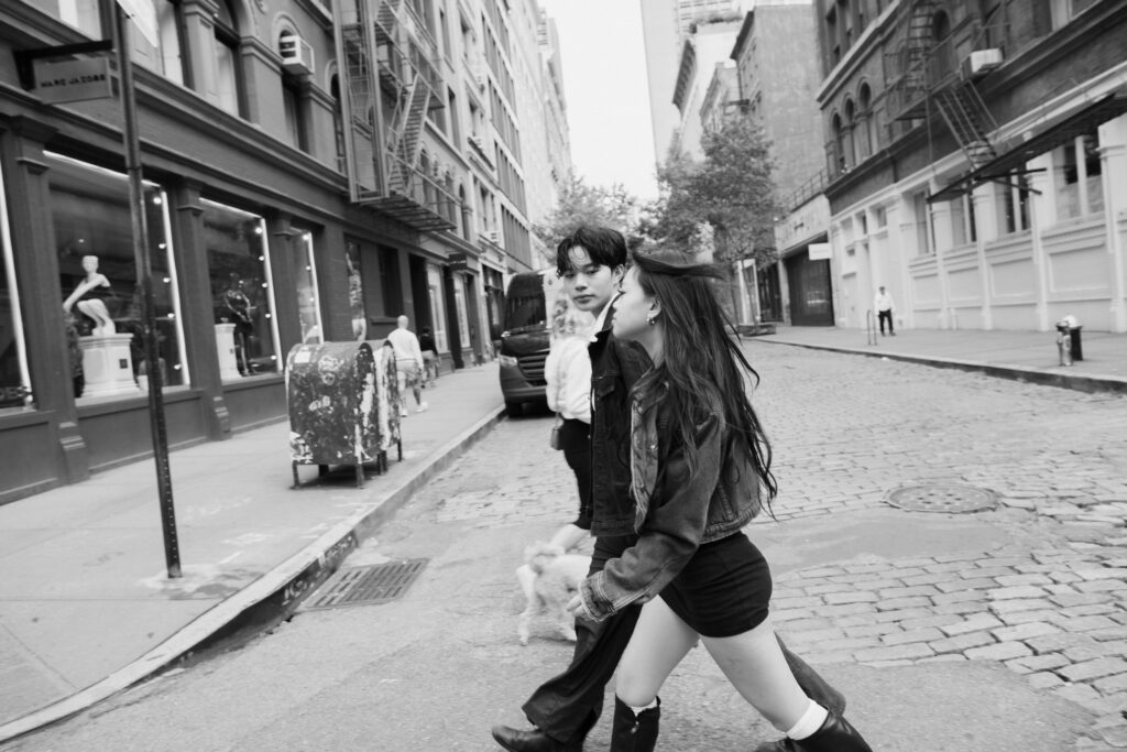 Black and White Image of couple running on the streets of Soho in NYC