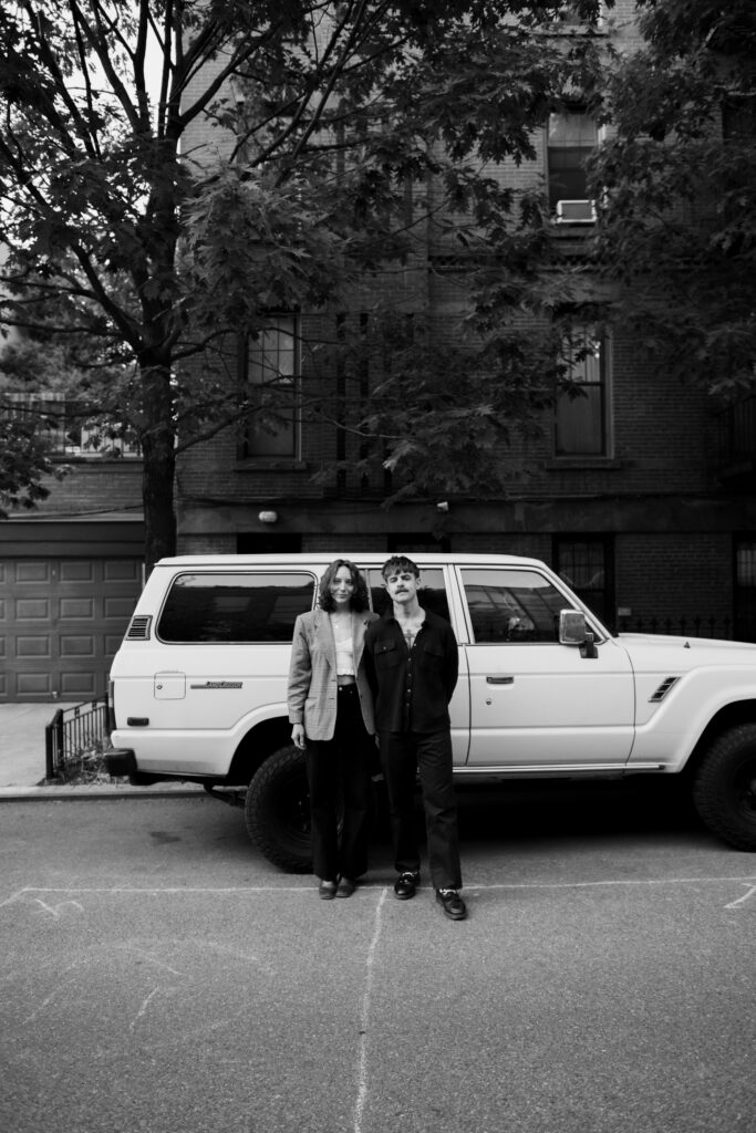 Couple posing in front of an old Land Cruiser on the streets in Brooklyn during their engagement session