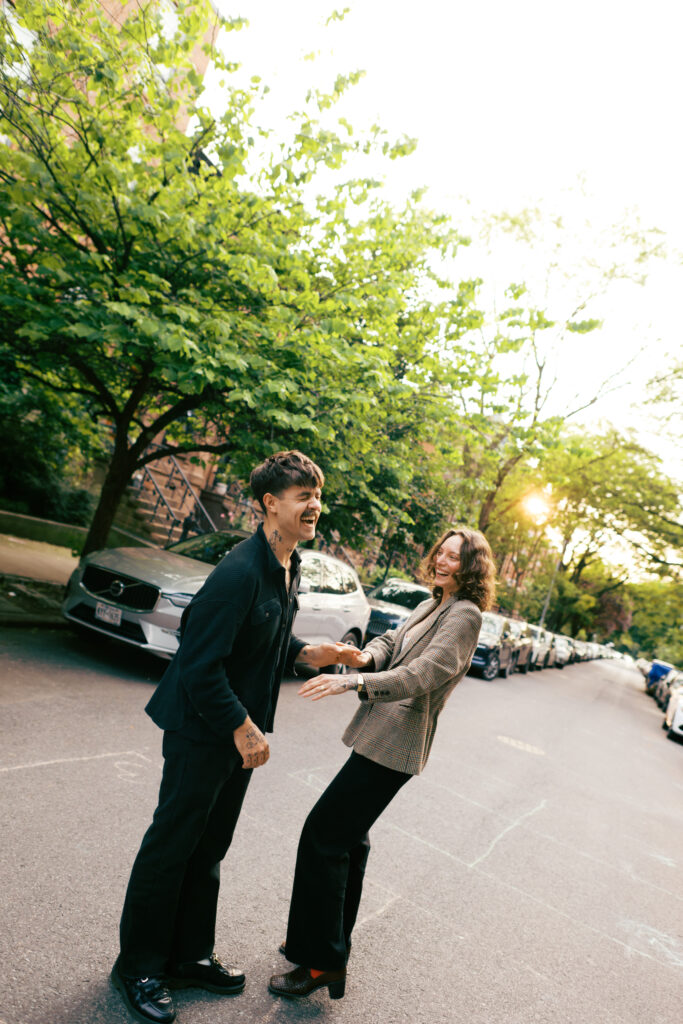 Couple dancing with a vintage Land Cruiser behind them in Brooklyn, New York during their engagement session