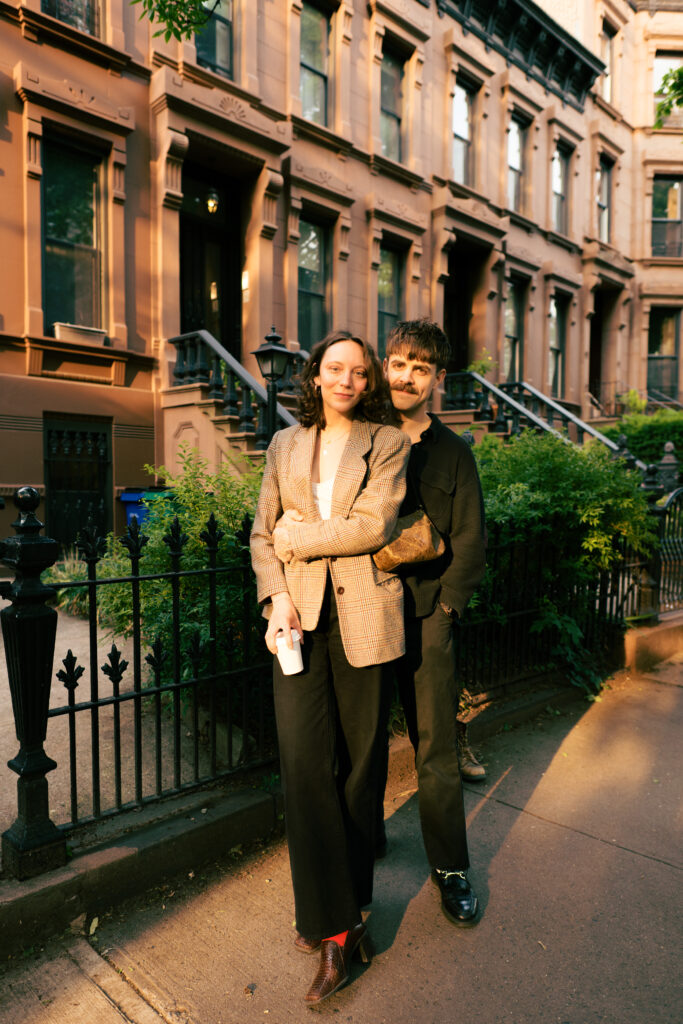 Groom snuggled up behind bride on the street in Park Slope during their Brooklyn Engagement session