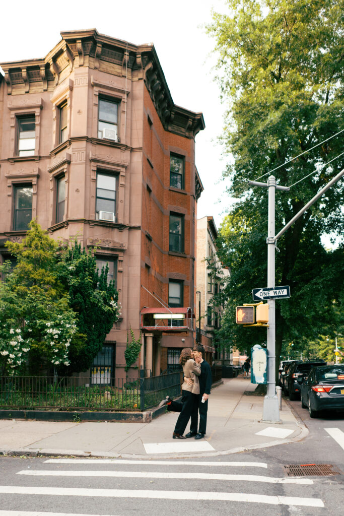 Couple kissing on the corner while waiting to cross the street during their Brooklyn engagement session 