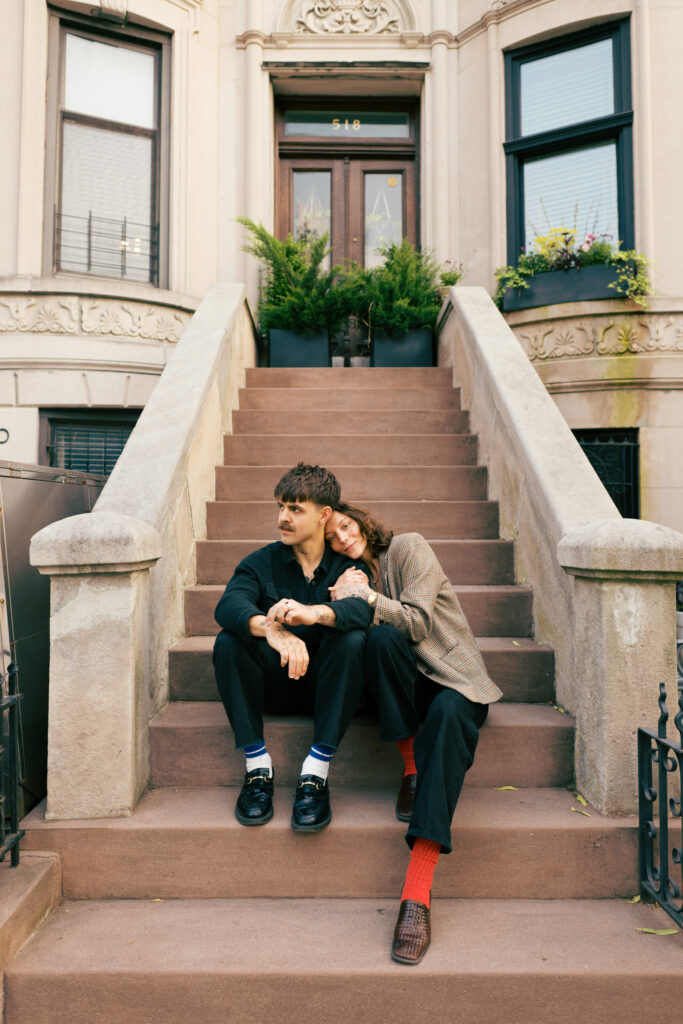 Couple sitting on the front stoop of a Brooklyn Brownstone during their Engagement session