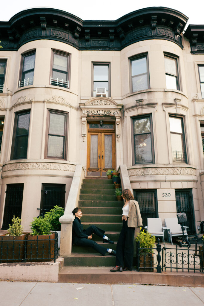 Couple sitting on the front stoop of a Brooklyn Brownstone during their Engagement session