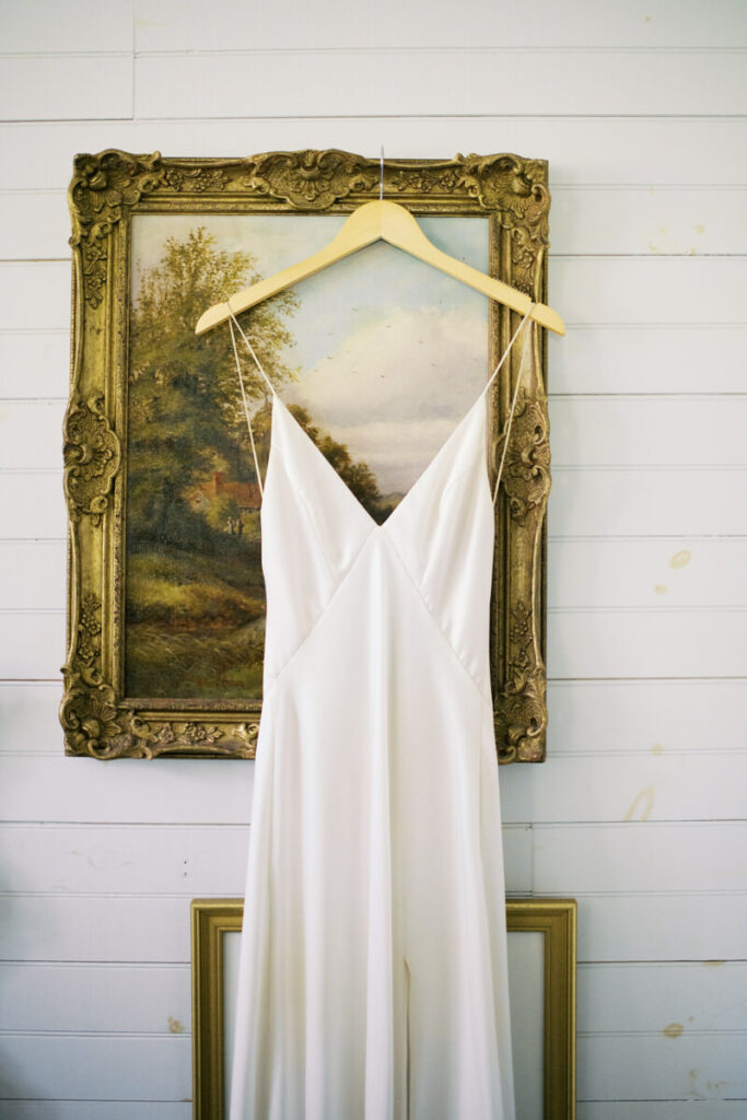 Editorial Wedding Photography of a wedding Dress hanging on a vintage picture frame