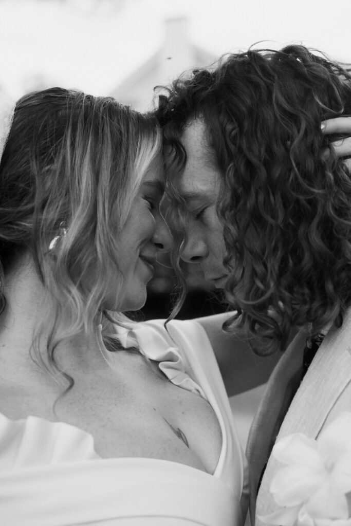 Black and white up close image of bride and groom forehead to forehead