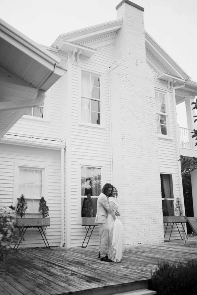 Black and white Editorial Wedding Photography of couple dancing on the porch of their wedding venue