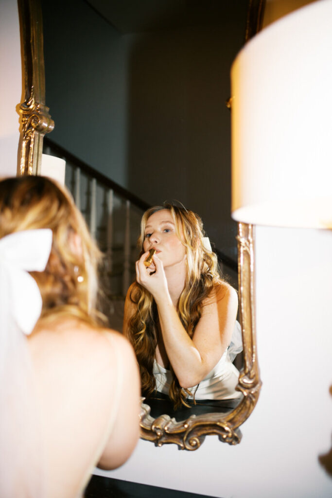 Bride re-doing her makeup in her second dress of the night