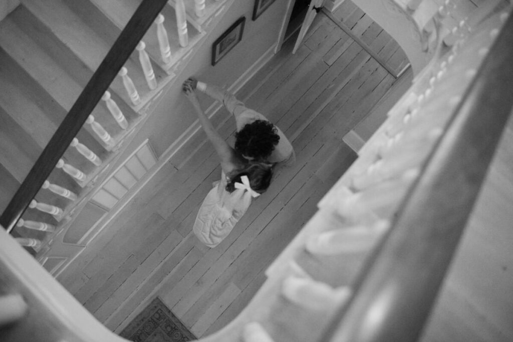 Black and white image of the couple dancing and kissing in the foyer of their wedding venue