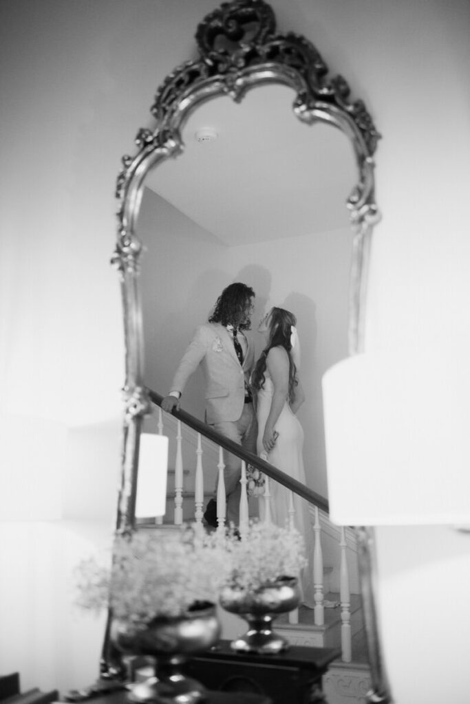 Black and white image of the couple dancing and kissing in the foyer of their wedding venue
