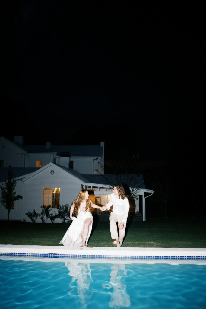 Bride and groom jumping in the pool atthe end of their wedding night