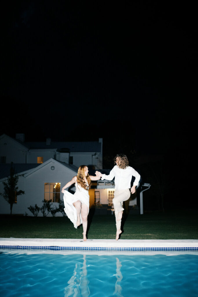 Bride and groom jumping in the pool atthe end of their wedding night