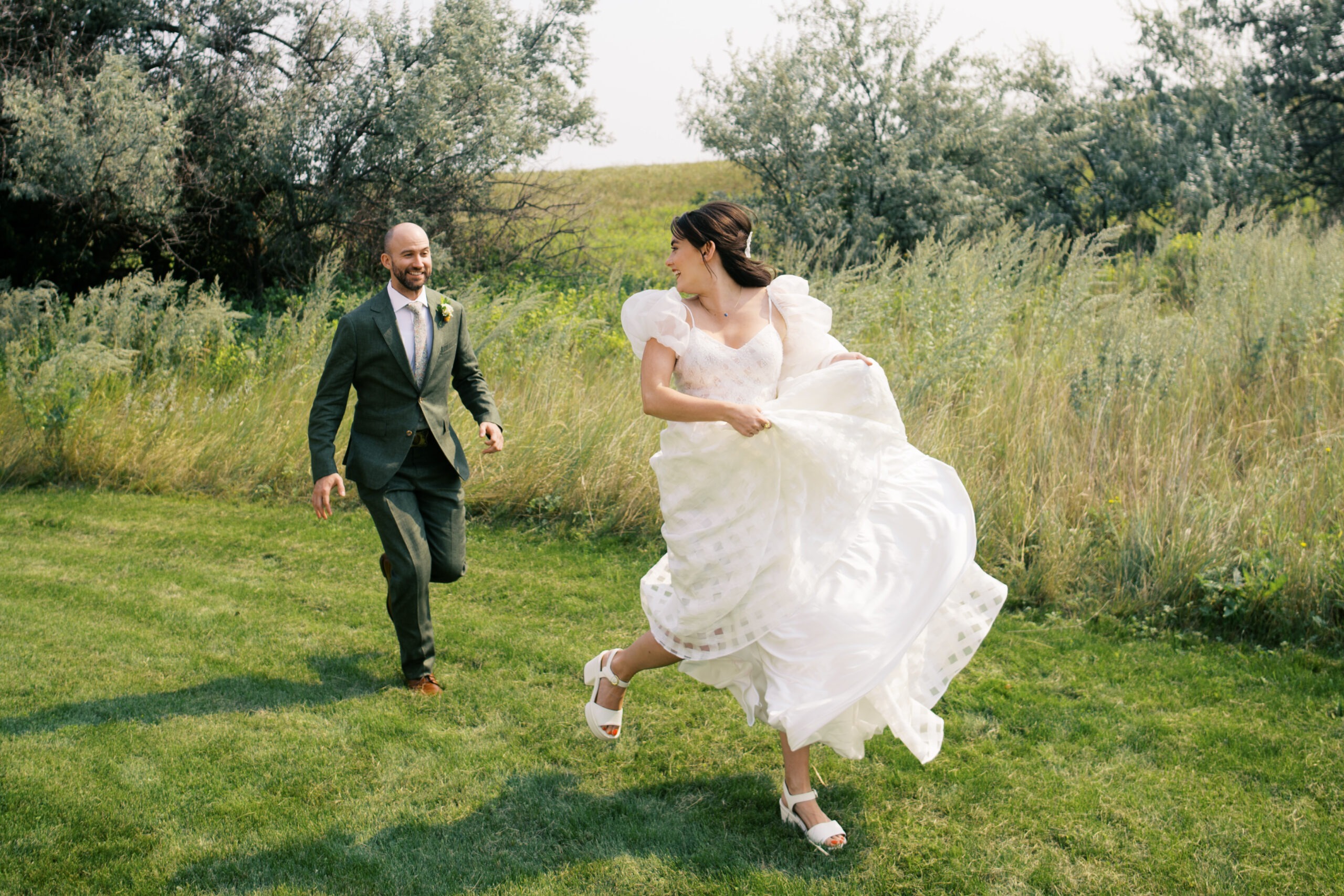 Couple running toward the camera on their wedding day in Upstate New York