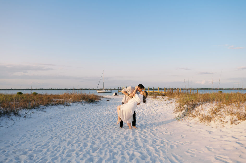 A couple snuggled in a blanket on the coast in Wilmington, North Carolina for their engagement sesion