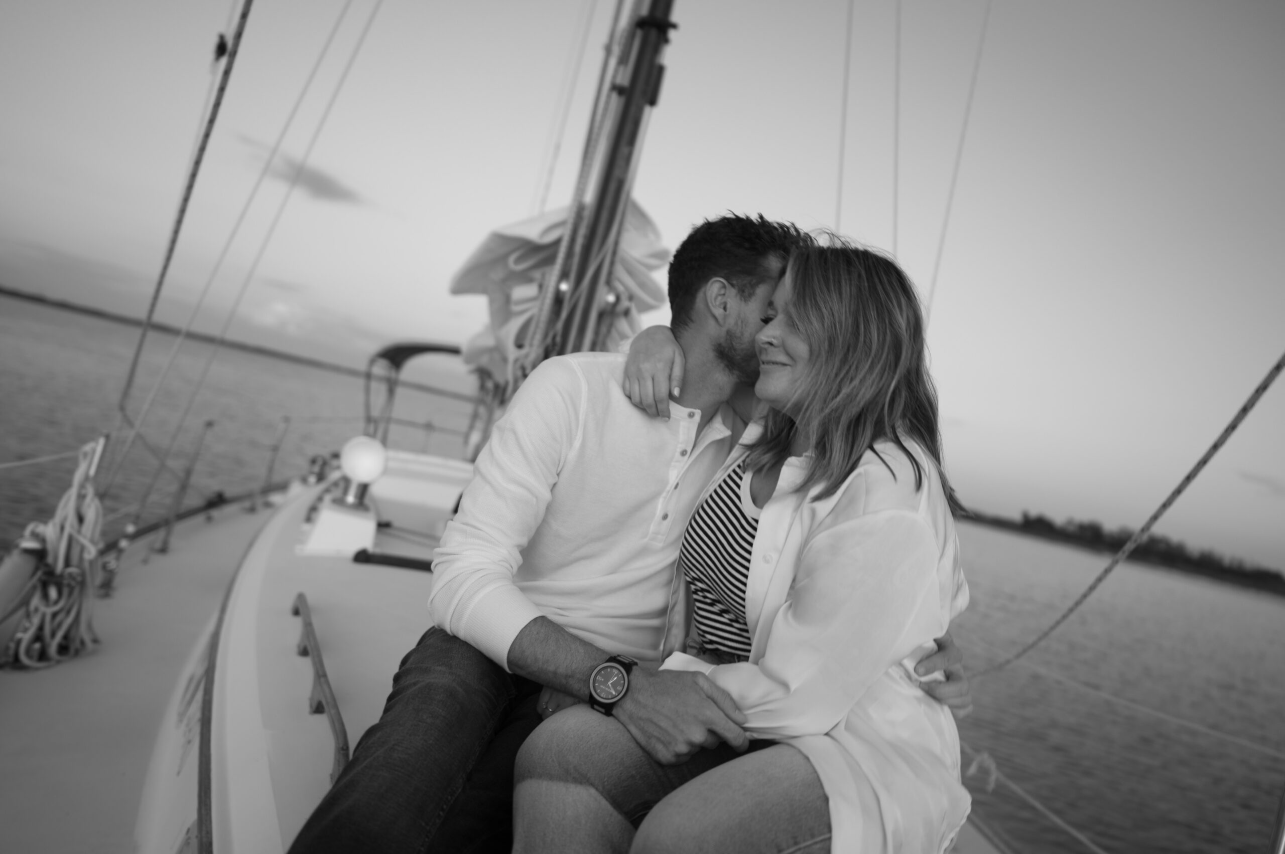 A couple kissing on their sailboat during their engagement session in Wilmington, North Carolina