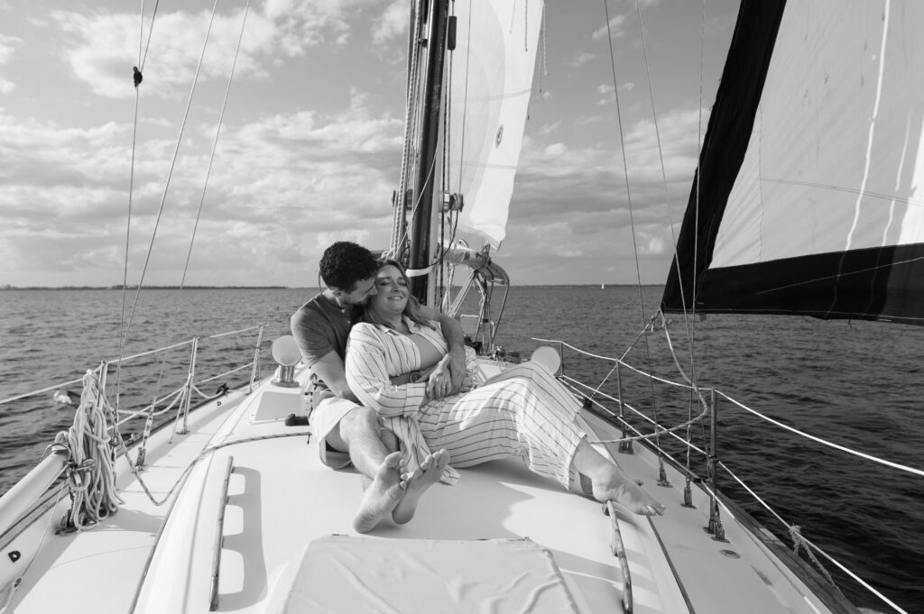 Black and white image of a sailboat with a couple sitting on it in Wilmington, North Carolina