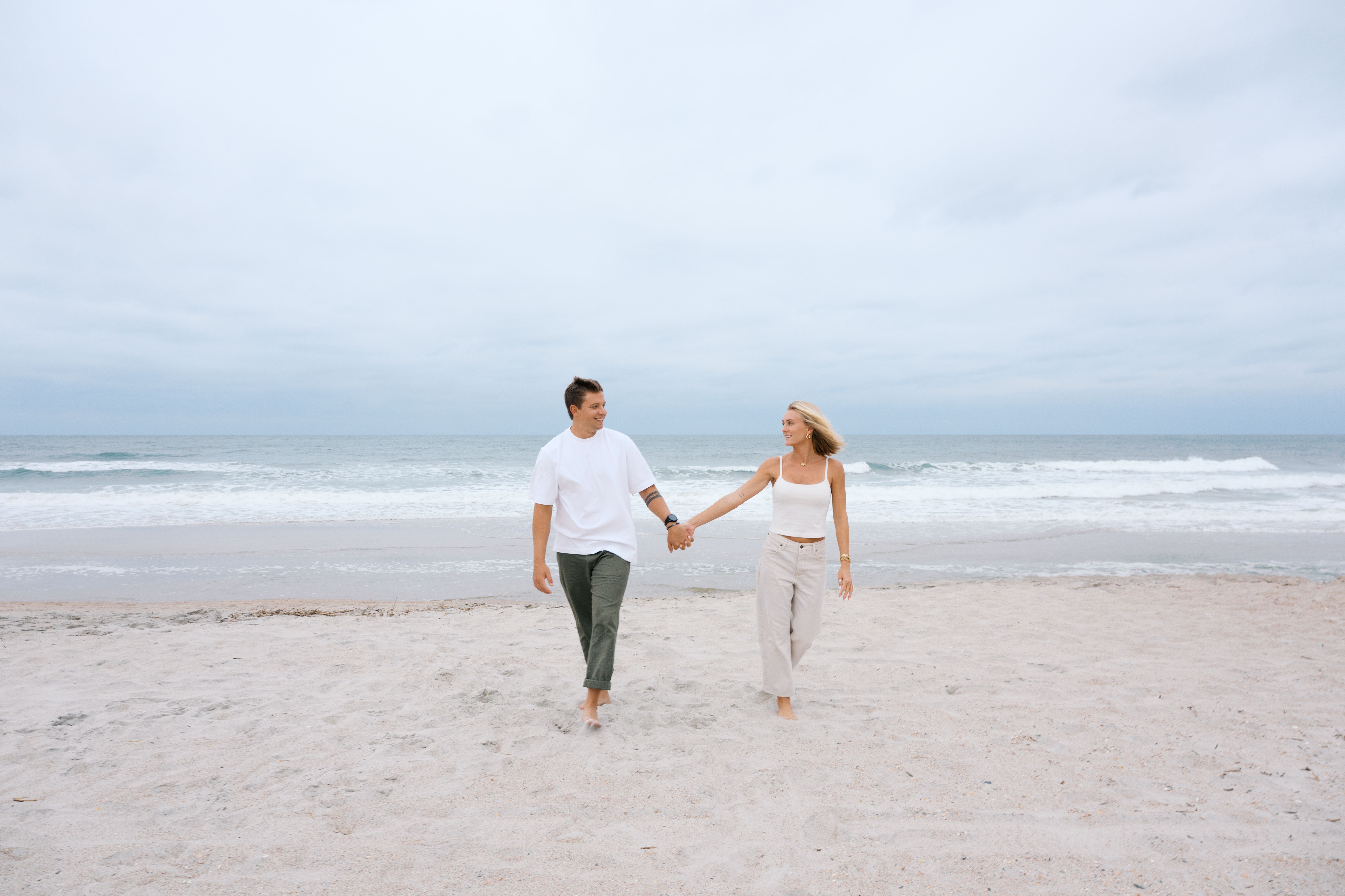 A couple, walking together, on the beach in Wilmington, at sunset.