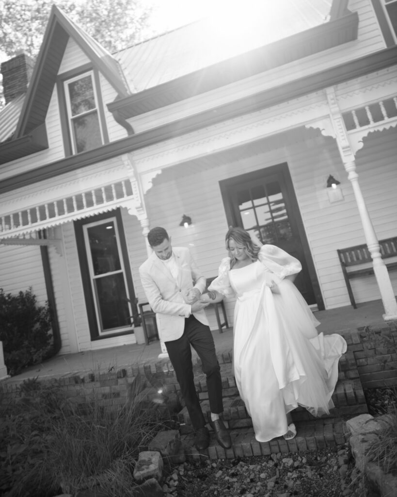 Black and white image of couple walking out of their wedding venue 